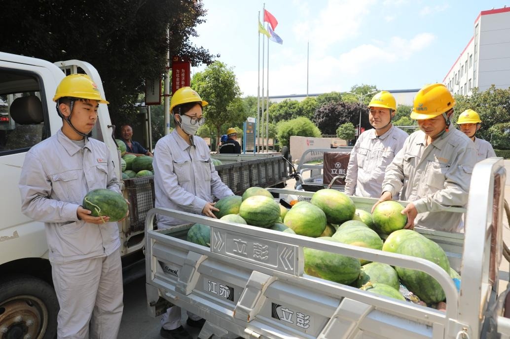 图为该公司员工在领西瓜.jpg 图为该公司员工在领西瓜.jpg
